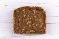 Slice of sunflower bread on white wooden background Royalty Free Stock Photo