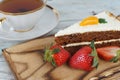 A slice of sweet carrot cake and a mug of tea next to red strawberries Royalty Free Stock Photo
