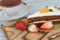 A slice of sweet carrot cake and a mug of tea next to strawberries Royalty Free Stock Photo