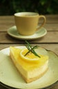 Slice of sweet and tart lemon cream cheese pie with coffee cup in the backdrop