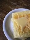 Slice of toast with condensed milk on top over wooden background.