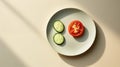 A slice of tomato and cucumber on a plate, top view, empty light space