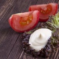 Slice of tomato. handful of mayonnaise swirl on green leaf Royalty Free Stock Photo