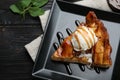 Slice of traditional apple pie with ice cream on black wooden table, flat lay Royalty Free Stock Photo
