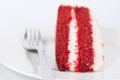 Slice of velvet cake with fork on white plate