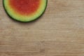 Slice of watermelon offset on the top of a worn bamboo cutting board Royalty Free Stock Photo