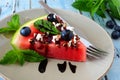 Slice of watermelon pizza close up with blueberries, feta and mint