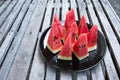 Slice watermelon in plate on wood table background. Pieces of watermelon in black dish on wooden table Royalty Free Stock Photo