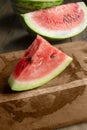 A slice of watermelon on a wooden board. Juicy watermelon on the table. A piece of watermelon in the form of a triangle Royalty Free Stock Photo