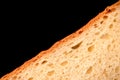 slice of white bread close up  on a black background. rough dappled textured surface chopped piece loaf of natural organic Royalty Free Stock Photo