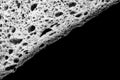 slice of white bread close up isolated on black background. gray rough textured surface chopped piece loaf of food with holes. top