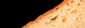 slice of white bread close up isolated on a black background. rough textured surface chopped piece loaf of natural organic food wi Royalty Free Stock Photo