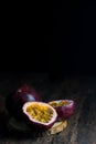 Slice and whole passion fruits put on a wooden cutting board on a rustic wooden floor. Royalty Free Stock Photo