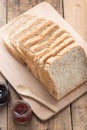 Slice of a whole wheat bread with samll jam jar on wood table