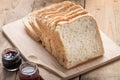 Slice of a whole wheat bread with small jam jar on wood table Royalty Free Stock Photo