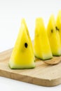 Slice yellow watermelon on wood plate isolated