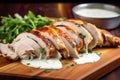 sliced alabama chicken revealing juicy interior, white sauce pooled nearby