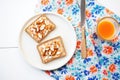 sliced almonds sprinkled over almond butter toast on a patterned napkin