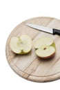 Sliced apple and knife on wooden plate over white background Royalty Free Stock Photo