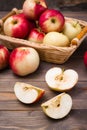 Sliced apple and ripe red apples on a wooden table and in a basket Royalty Free Stock Photo