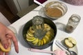 Sliced apples in a baking dish. Nearby is dough and other ingredients and tools for making charlotte. Autumn pie with apples