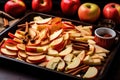 sliced apples and cinnamon sticks on a tray