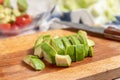 Sliced avocado salad on a wooden cutting board. Cook at home