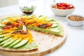 sliced avocado topping on a raw vegan pizza, with chili flakes