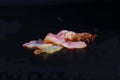 Sliced bacon on a black background. Bacon for burger. Royalty Free Stock Photo