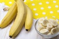 Sliced banana in bowl on white wooden background. Royalty Free Stock Photo