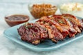 Sliced barbeque ribs on blue plate with side dishes Royalty Free Stock Photo