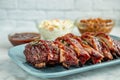 Sliced barbeque ribs on blue plate with side dishes Royalty Free Stock Photo