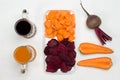 Sliced beets and carrots in white plate. Root vegetable of beets and carrots. Two glasses of beetroot and carrot juice Royalty Free Stock Photo