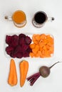 Sliced beets and carrots in white plate. Root vegetable of beets and carrots. Two glasses of beetroot and carrot juice Royalty Free Stock Photo