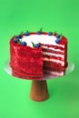 Sliced Birthday cake on the wooden cake stand. Beautiful sponge cake on the paper background. Copy space. Food photography for