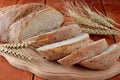 Sliced black bread on a cutting board, ears of wheat. Royalty Free Stock Photo