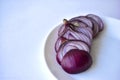 Sliced blue onion on a white plate close-up Royalty Free Stock Photo