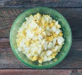 Sliced boiled eggs in a green bowl on the old wooden table Royalty Free Stock Photo