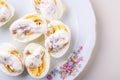 Sliced boiled eggs with mayonnaise and pepper in white plate isolated Royalty Free Stock Photo