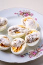 Sliced boiled eggs with mayonnaise and pepper in white plate isolated Royalty Free Stock Photo