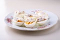 Sliced boiled eggs with mayonnaise and pepper in white plate isolated Royalty Free Stock Photo