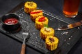 Sliced boiled corn ear with salt, chili peppers, butter and tomato sauce on slate board Royalty Free Stock Photo