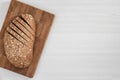 Sliced bread with seeds and flakes on wooden board on white background.