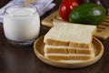 Sliced bread toped with condensed milk on wooden plate Royalty Free Stock Photo