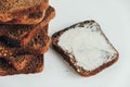 Sliced of brown bread with butter on a white wooden background. Top view. Copy, empty space for text Royalty Free Stock Photo