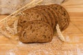 Sliced brown bread among different ears, wheat grain and flour Royalty Free Stock Photo