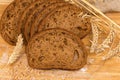 Sliced brown bread among different ears, wheat grain and flour Royalty Free Stock Photo