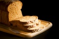 Sliced brown bread on wooden chopping board