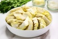 sliced canned artichoke hearts arranged in a white bowl