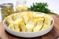 sliced canned artichoke hearts arranged in a white bowl